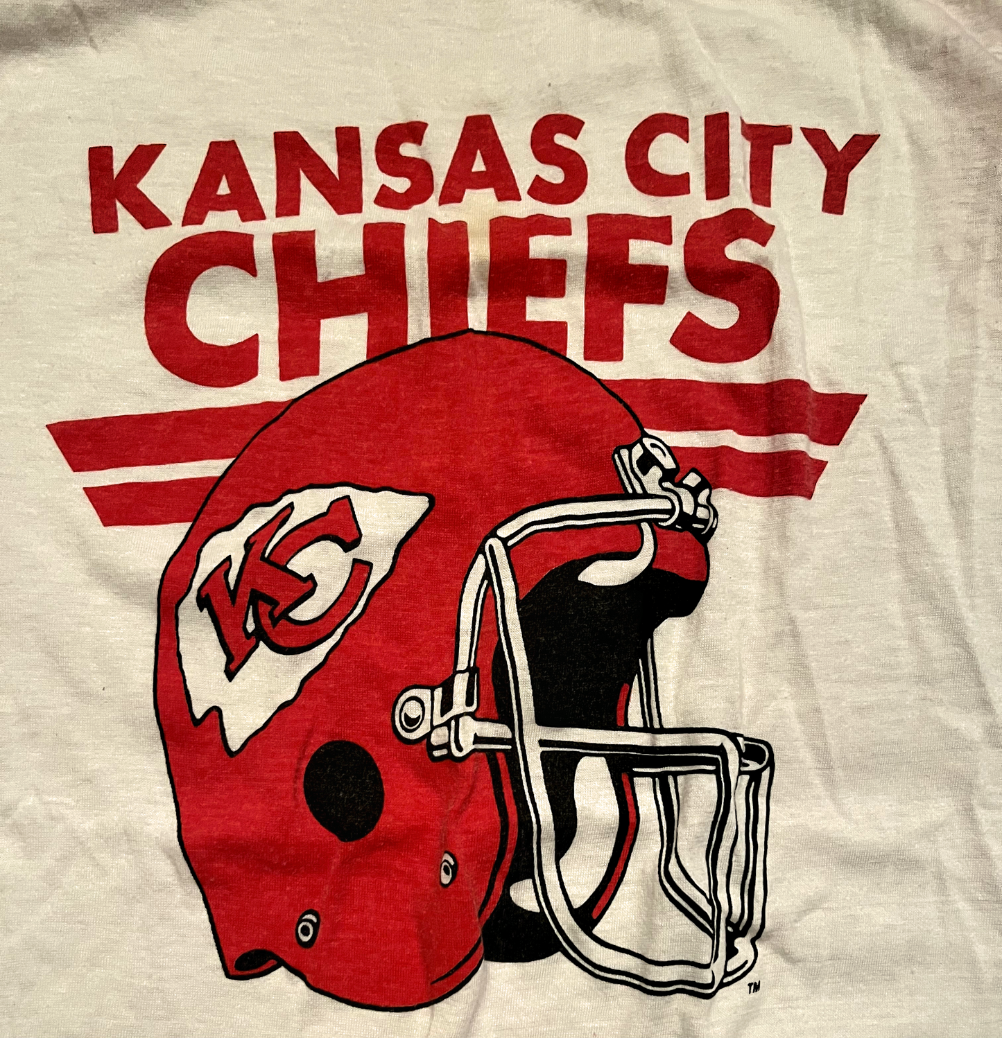 Close up of graphic of red and white Kansas City Chiefs tee lay down on white background.